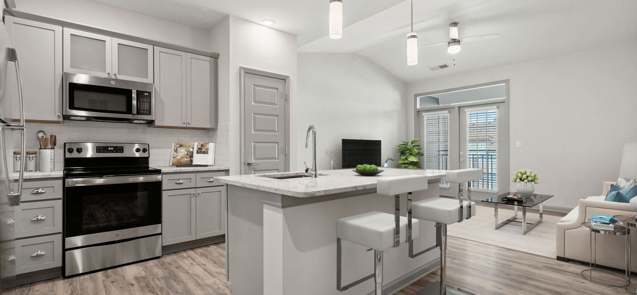 Hawthorne at Westport apartment kitchen interior with kitchen island, stainless steel appliances, and white cabinetry