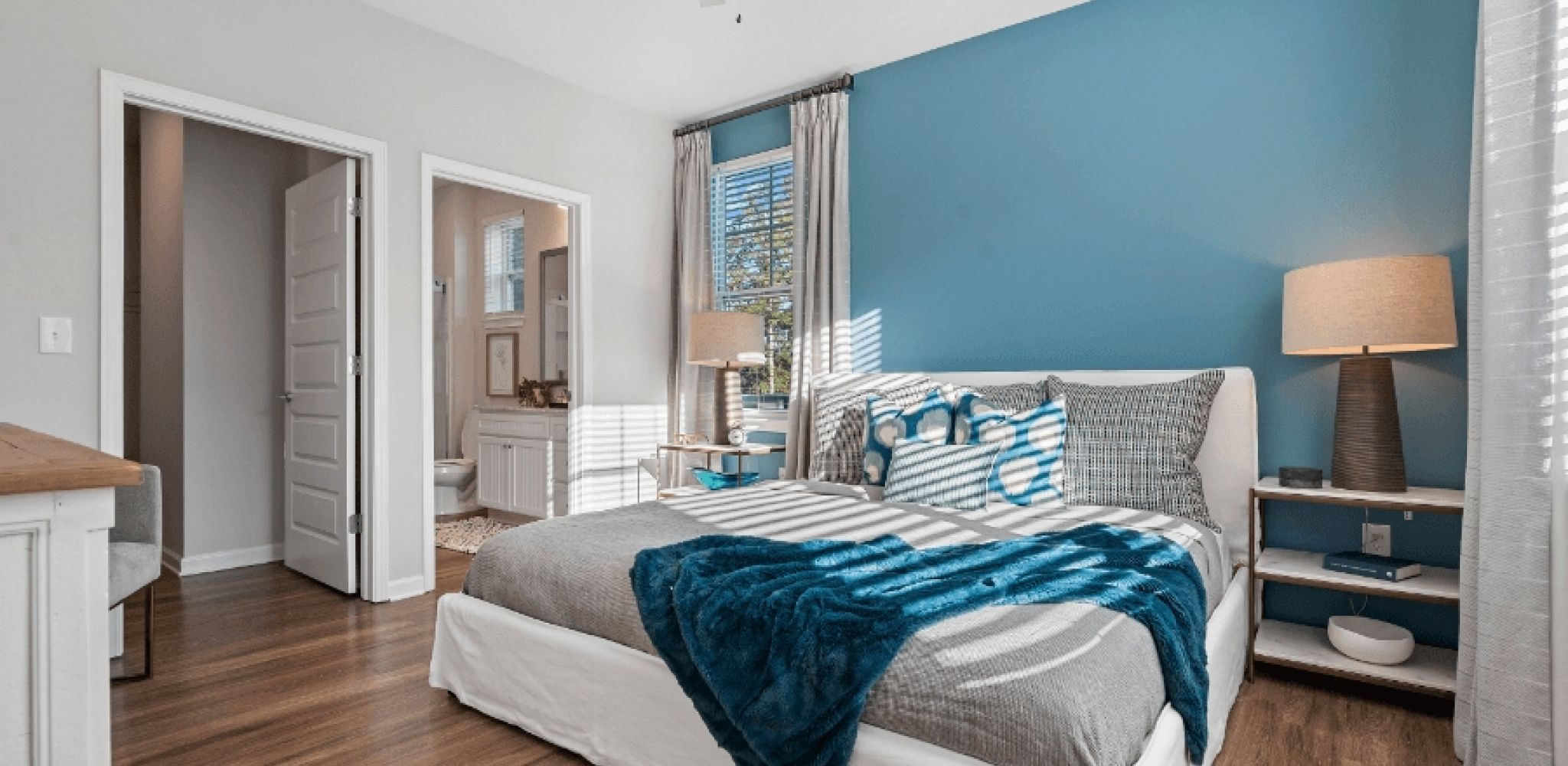Hawthorne at Westport spacious apartment bedroom with blue accent wall and bed